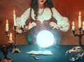 Fantasy retro women& x27;s hands close-up, witch feel energy magic of glowing crystal ball. dark gothic room. Photo of old