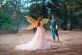 fantasy romantic couple in love. Prince happy man goes to meet girl princess in forest. Elf woman in pink dress train Royalty Free Stock Photo