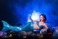 Fantasy stupid mermaid in deep ocean. Plastic trash and bottles pollution in ocean. Ecocatastrophe, garbage and plastic