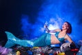 Fantasy stupid mermaid in deep ocean. Plastic water bottles and bags pollution on sea floor. Environmental problem.