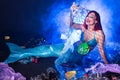 Fantasy stupid mermaid in deep ocean. Plastic water bottles and bags pollution on sea floor. Environmental problem.
