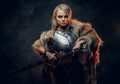 Fantasy woman knight wearing cuirass and fur, holding a sword scabbard ready for a battle. Fantasy fashion. Cosplayer as Royalty Free Stock Photo