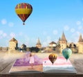 Fantasy worlds in fairytales. Book, hot air balloons and enchanted castle on background