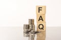 FAQ - Frequency Asked Questions - acronym on wooden cubes on white background with coins Royalty Free Stock Photo