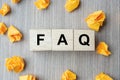 FAQ frequency asked questions word with wooden cube block and yellow crumbled paper on table background. Answer, Question, Ask, Royalty Free Stock Photo