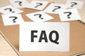 FAQ on a piece of paper and many question marks on notebook. Royalty Free Stock Photo