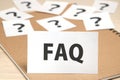 FAQ on a piece of paper and many question marks on notebook. Royalty Free Stock Photo