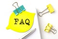 FAQ text on yellow sticker on notebook with pen Royalty Free Stock Photo