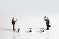 frequently asked questions abbreviation with miniature businessmen figurines having a gathering Royalty Free Stock Photo