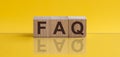 FAQ - word from wooden blocks with letters, sorry concept, yellow background