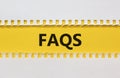 FAQS, frequently asked questions symbol. White and yellow paper. Words `FAQS, frequently asked questions`. Beautiful yellow Royalty Free Stock Photo