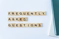 FAQS or Frequently asked questions word made with building blocks isolated on white. Wooden blocks with the word FAQ