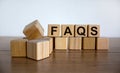 FAQS symbol. Wood cubes with word `FAQS - frequently asked questions` on beautiful wooden table, white background, copy space. Royalty Free Stock Photo