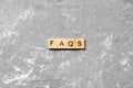 Faqs word written on wood block. faqs text on table, concept