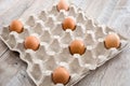 Far apart chicken eggs in a cardboard box on a wooden table. Infection prevention concept. Social distance. Royalty Free Stock Photo