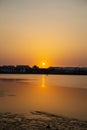 Far away, against the backdrop of a shui town, a fisherman is fishing on the lake from an inflatable small boat, against Royalty Free Stock Photo