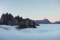 Far away from the ground. The peaks of the mountains stifle from a going thick fog. Unbelievable photo takes