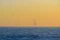 Far away oil platform at sunrise