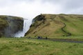 Far away photograph of Skogfoss waterfall showing the steps to the top