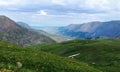 Far wide view of an alpine valley from the Karagem pass in Altai with mountain ranges against a sky with clouds in summer Royalty Free Stock Photo