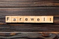 Farewell word written on wood block. farewell text on table, concept