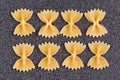 Farfalle closeup on grey background. Raw pasta bow tie. food background Royalty Free Stock Photo