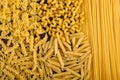 Farfalle, fettuccine, noodles, fusilli and penne rigate. Different kinds of pasta on a wooden background. Tasty Italian cuisine.