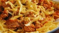 Farfalle pasta in bolognese sauce with beef and tomato rotates in a circle