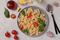 Farfalle pasta with cherry tomatoes, tomato sauce and basil on white background, close up, View from above Royalty Free Stock Photo