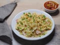 Farfalle pasta with ham, cheese and green onions in a plate and napkin on the table, closeup, flat layout. Fast recipe Royalty Free Stock Photo