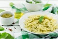 Farfalle pasta with pesto genovese basil sauce on white rusti