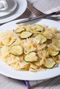 Farfalle pasta with zucchini closeup with knife and fork