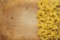 Farfalle macaroni Beautiful laid out pasta with the right, side on a wooden plank texture background. Close-up view from the top.