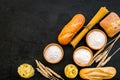 Farinaceous food. Fresh bread and raw pasta near flour in bowl and wheat ears on black background top view copy space Royalty Free Stock Photo