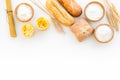 Farinaceous food. Fresh bread and raw pasta near flour in bowl and wheat ears on white background top view copy space