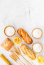 Farinaceous food. Fresh bread and raw pasta near flour in bowl and wheat ears on white stone background top view copy