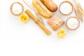 Farinaceous food. Fresh bread and raw pasta near flour in bowl and wheat ears on white background top view copy space