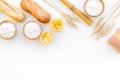 Farinaceous food. Fresh bread and raw pasta near flour in bowl and wheat ears on white background top view space for