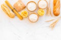 Farinaceous food. Fresh bread and raw pasta near flour in bowl and wheat ears on white stone background top view space