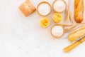 Farinaceous food. Fresh bread and raw pasta near flour in bowl and wheat ears on white stone background top view space