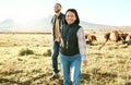 Farm, agriculture and cattle with a couple walking on a field or meadow together for beef of dairy farming. Cow Royalty Free Stock Photo