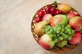 Farm apples, pears, grapes and plums in a wicker wooden plate on the table. Harvest of autumn fruits. Copy Space Royalty Free Stock Photo