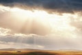 A farm in autumn fields under sunset clouds, sunlight floods