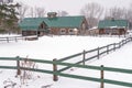 Farm barn and corral fences in snowstorm Royalty Free Stock Photo