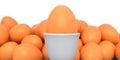 Farm brown painted egg in ceramic egg cup and crowd of eggs on white background Royalty Free Stock Photo
