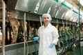 Woman in bathrobe working with automatical cow milking machines