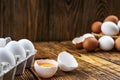 Farm eggs white and brown lie on a wooden table in a cardboard box and a basket, closeup, low light, selective focus Royalty Free Stock Photo