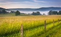 Farm field and distant mountains on a foggy morning in the rural Royalty Free Stock Photo