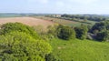 Farm fields, green pastured, hedgerow paths in English rural countryside