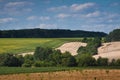 Arm fields with soybean, sunflowers and wheat, pasture land, forest bands on a sunny summer day with little clouds and shades Royalty Free Stock Photo